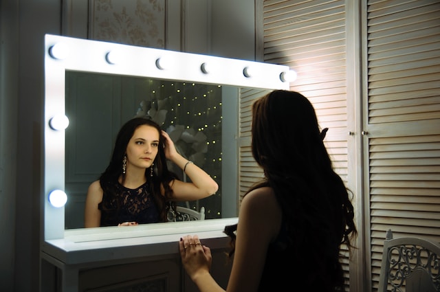 fille regardant dans le miroir avec des lampes